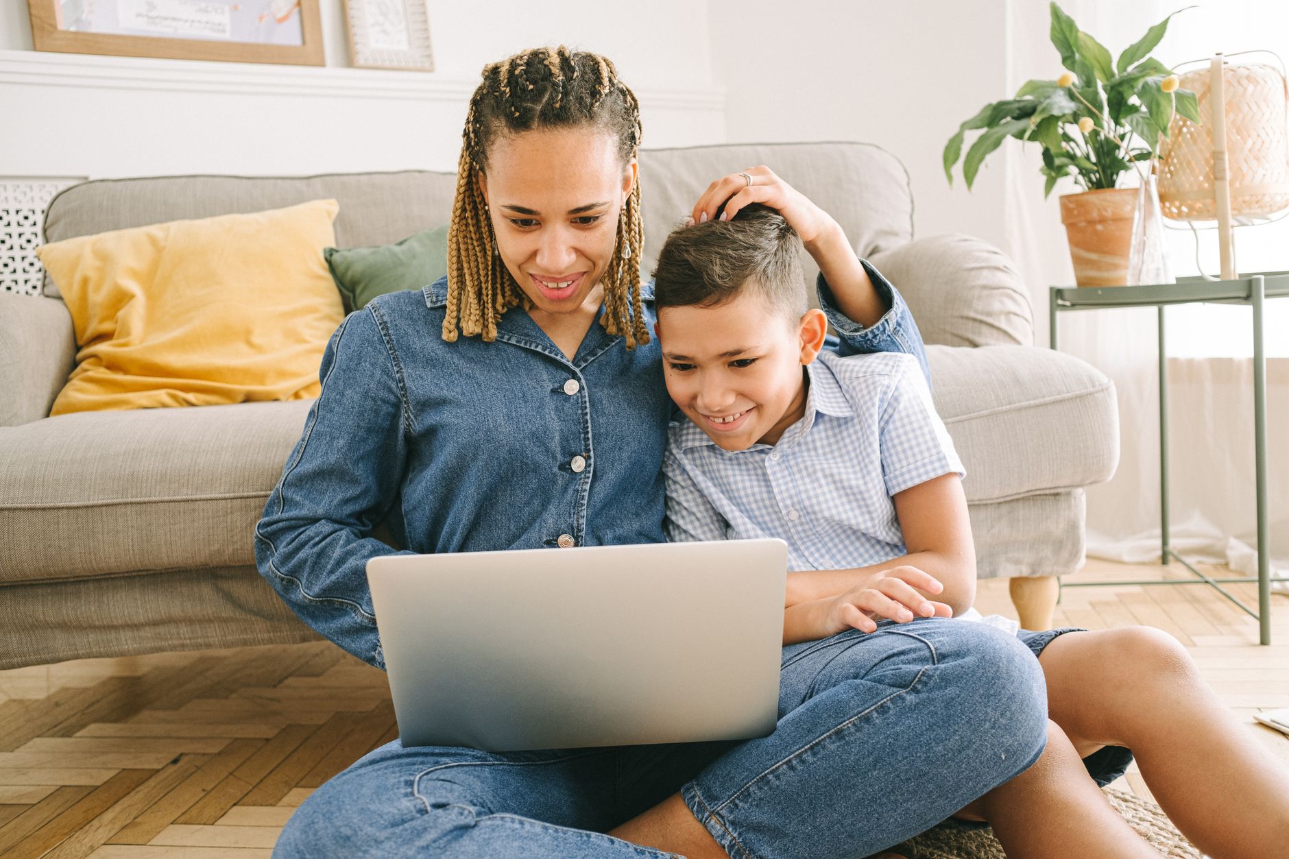 A parent and child looking at a laptop together on the couch