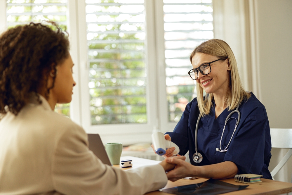 A provider checking a patient's temperature with a non-contact thermometer