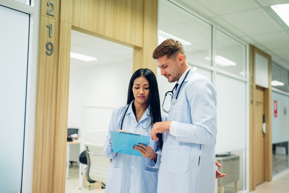 Two providers reviewing notes together in a clinic hallway